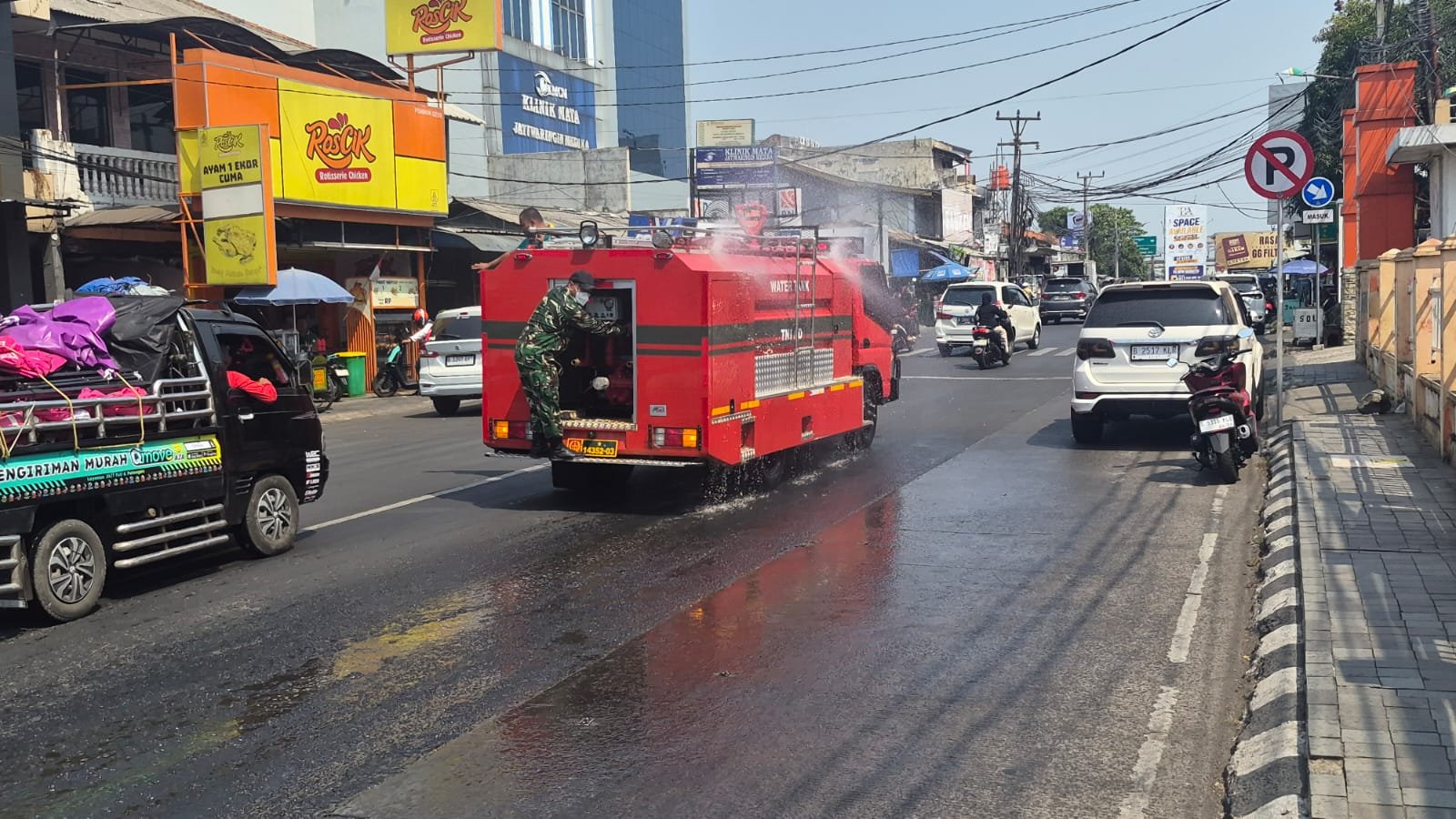 Atasi Jalan Berdebu Akibat Abu Vulkanik, Koramil 02/Pondok Gede Lakukan Penyemprotan di Wilayah Kota Bekasi